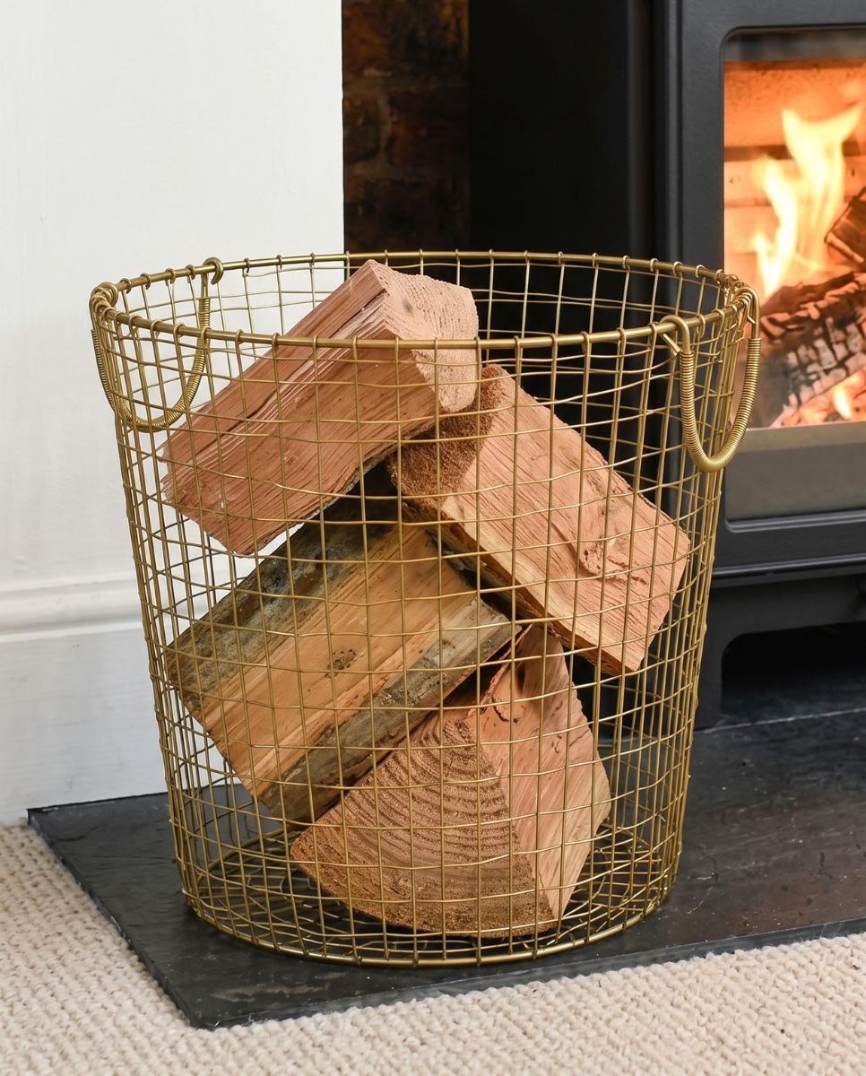 The 41cm Brass Plated Wire Log Basket adjacent to Lit Log Burner Stove in a Modern Home - Digital Illustration  
