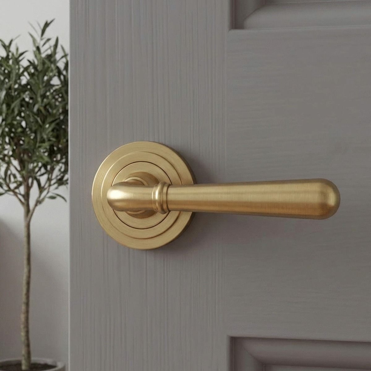 The 53mm Modern Satin Brass "Neville" Unsprung Art-Deco Door Handle on Rose Set on a Light Grey Door in a Clean and Modern Interior Setting - Digital Illustration 
