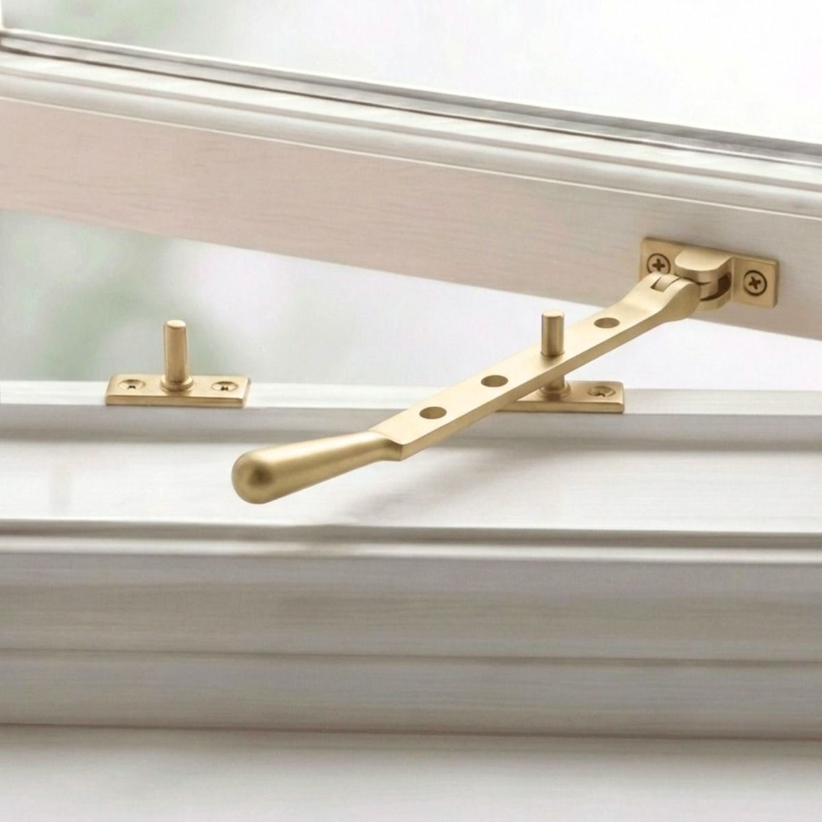 The 8" Satin Brass Three Pin Window Stay Mounted on a Wooden Window Frame - Digital Illustration