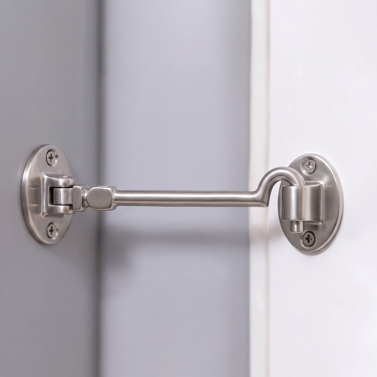 The 8 Inch Satin Chrome Cabin Hooks Silent Type Heavy  on a White Door in a Modern Home Interior - Digital Illustration