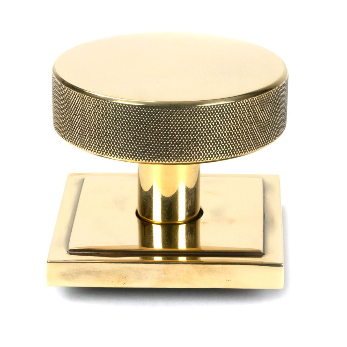 The Aged Brass Knurled Centre Door Knob on Square Rose Shown Upright on a White Background 
