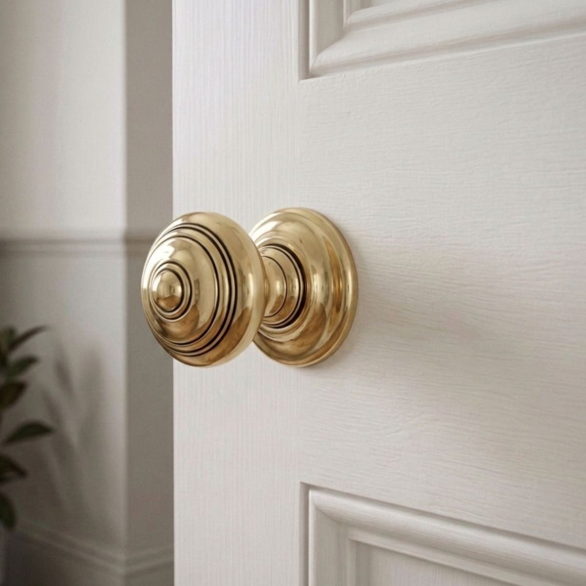 The Antique Brass Concealed Mortice Door Knob Set on a White Coloured Door in a Modern Home Interior - Digital Illustration