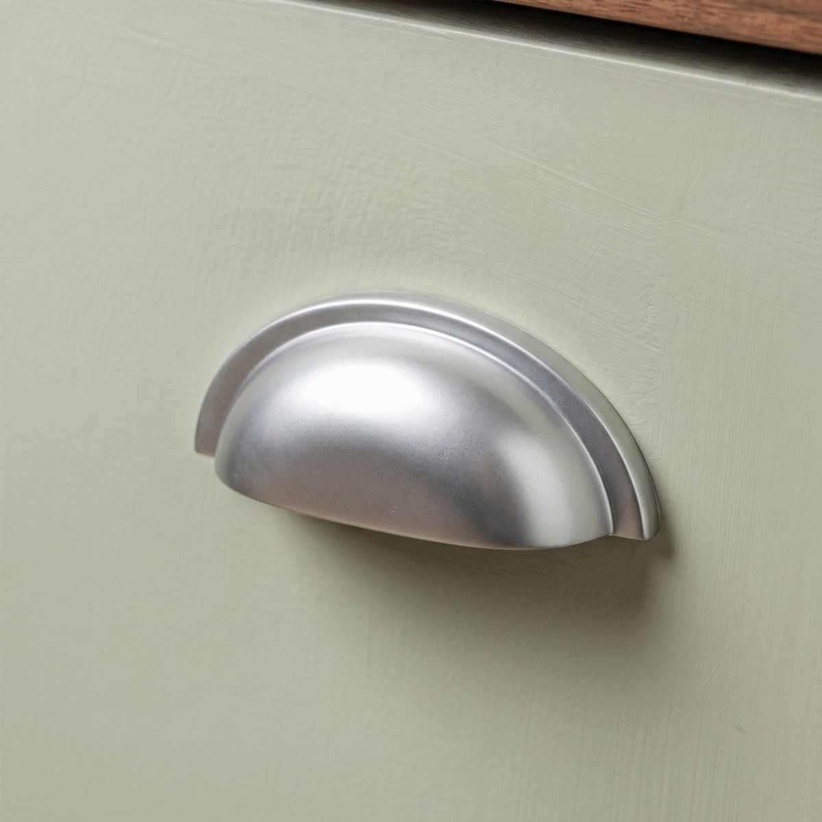 The Art Deco Concealed Cup Drawer Pull in Satin Chrome Mounted on an Olve Green Drawer - Digital Illustration 