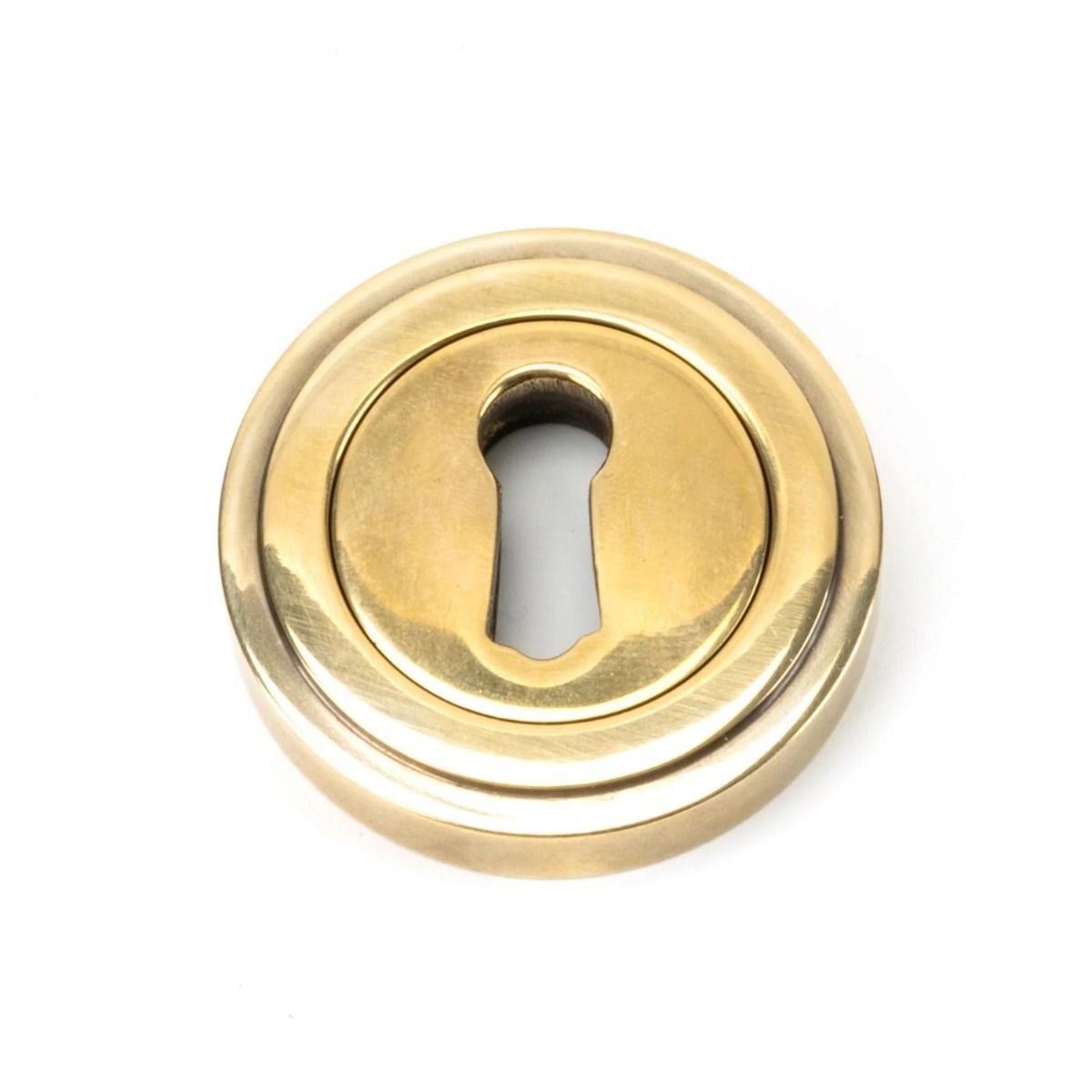 The Art Deco Concealed Standard Keyhole Escutcheon - Aged Brass on a White Background 