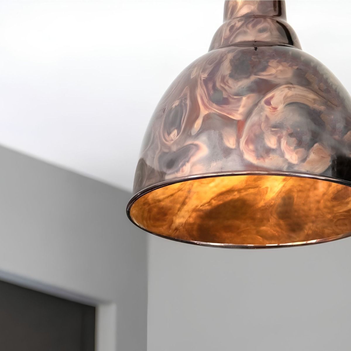 The Aura Dome Pendant Light in Burnished Brass Shown Lit up and Close up