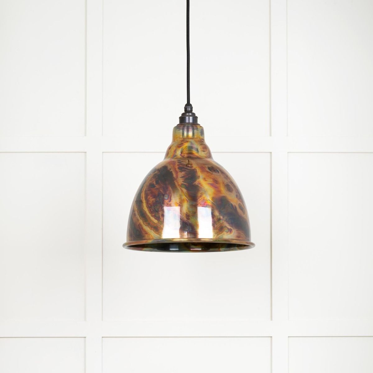 The Aura Dome Pendant Light in Burnished Brass Shown with the Light off on a White Panelled Background