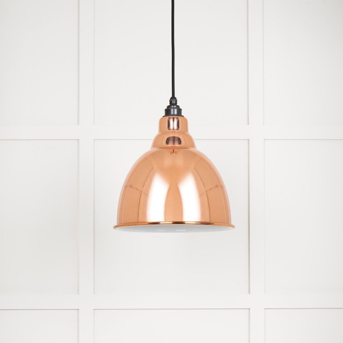 The Aura Dome Pendant Light in Copper and White Gloss Shown with the Light off on a White Panelled Background