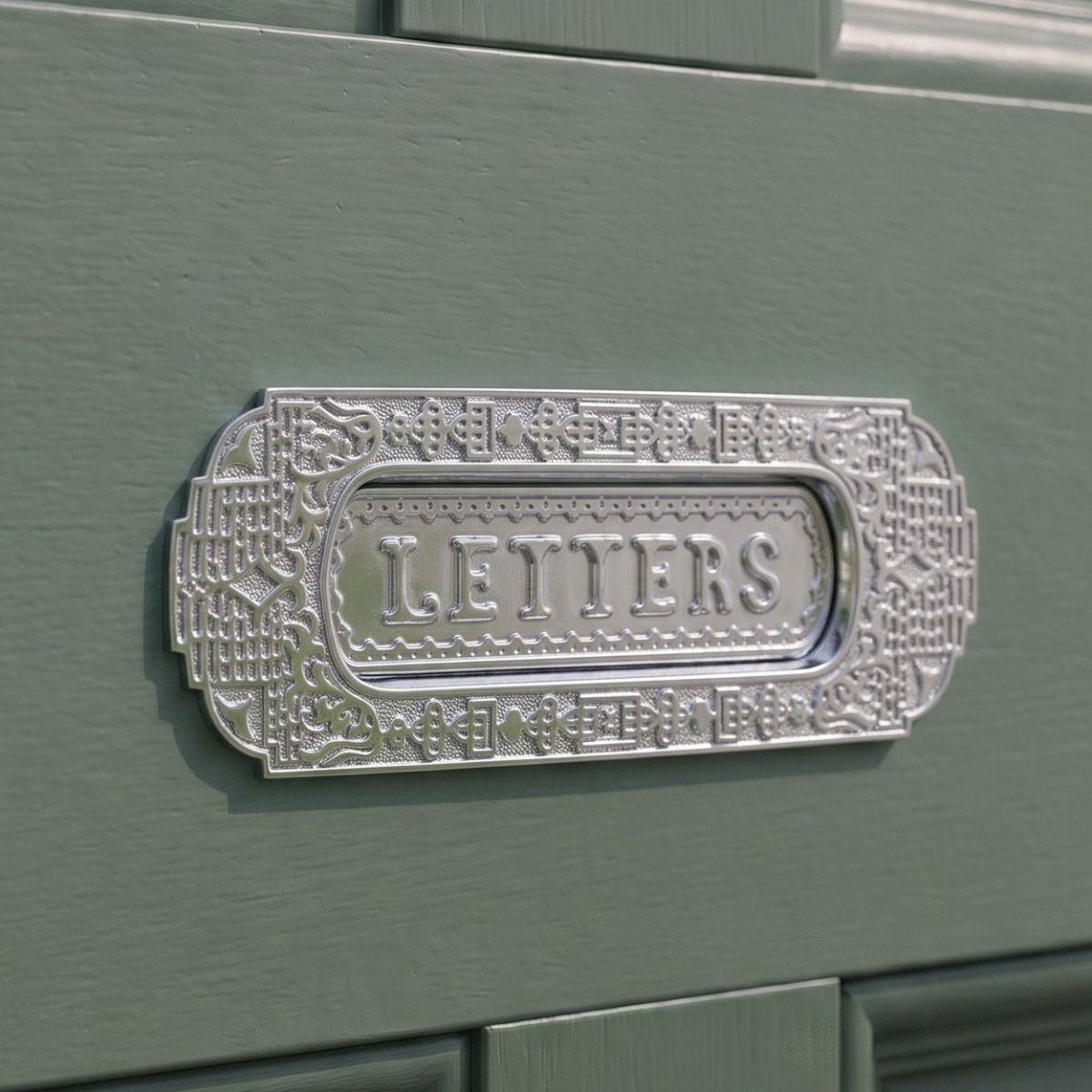 The Aztec Style Letter Plate in a Polished Chrome Finish on a Complementary Green Coloured Wooden Door - Digital Illustration 