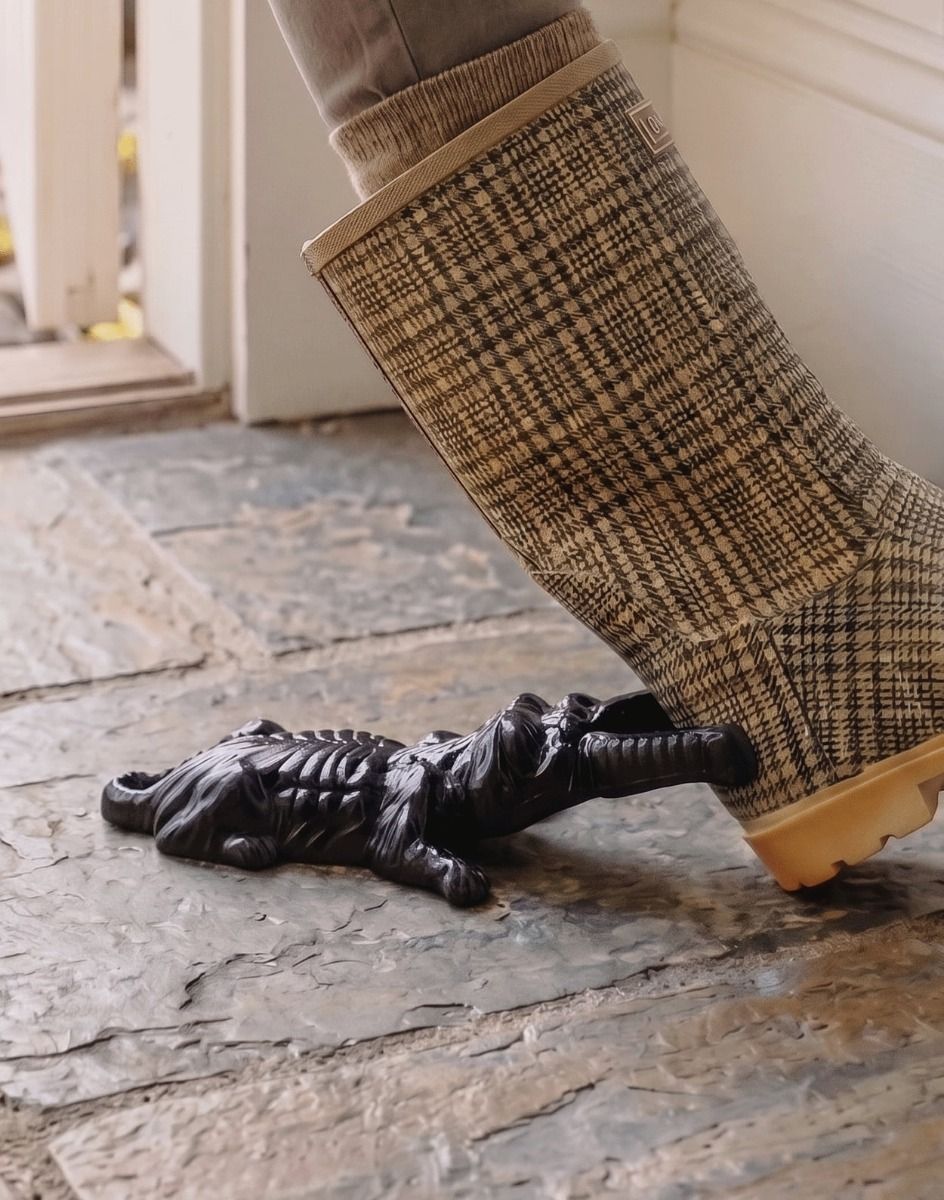 The Black Dog and Bone Boot Jack Placed at the Entrance of a Rustic Cottage Porch Viewed from the Side- Digital Illustration