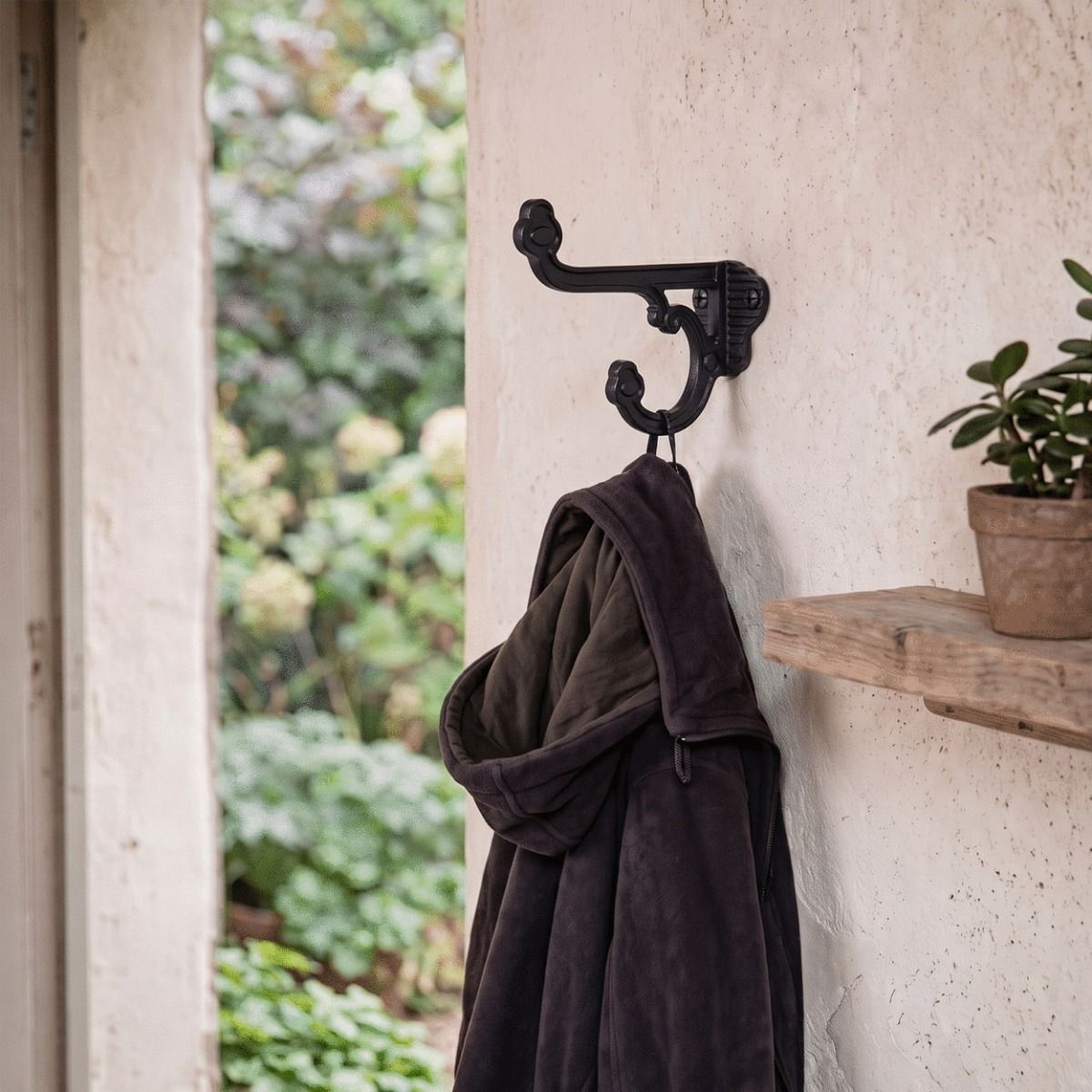 The Black Iron Priory Coat Hook Next to a Home Doorway with a Coat on it - Digital Illustration 