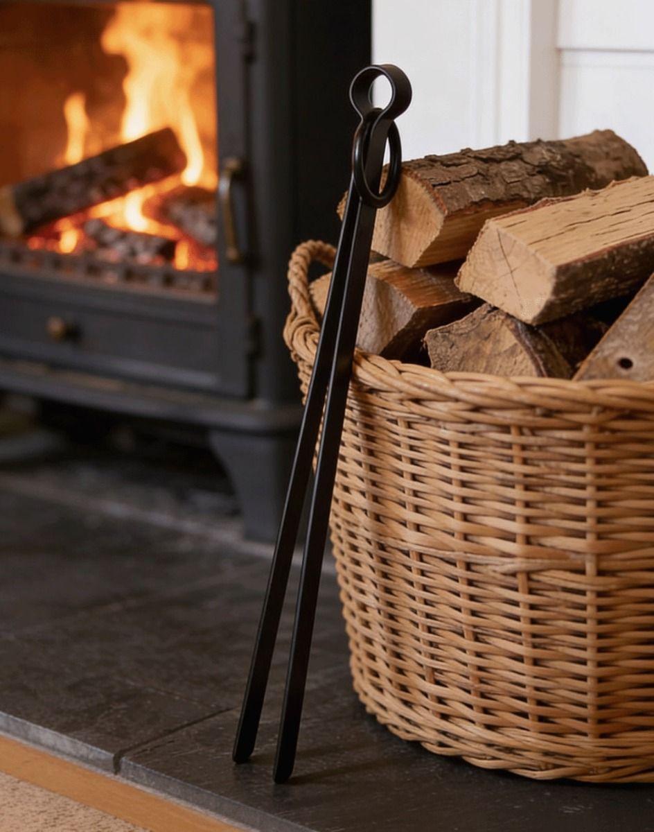 The Black Simplistic Fireside & Firepit Tongs Leaned up against a Log Basket on a Fireplace - Digital Illustration