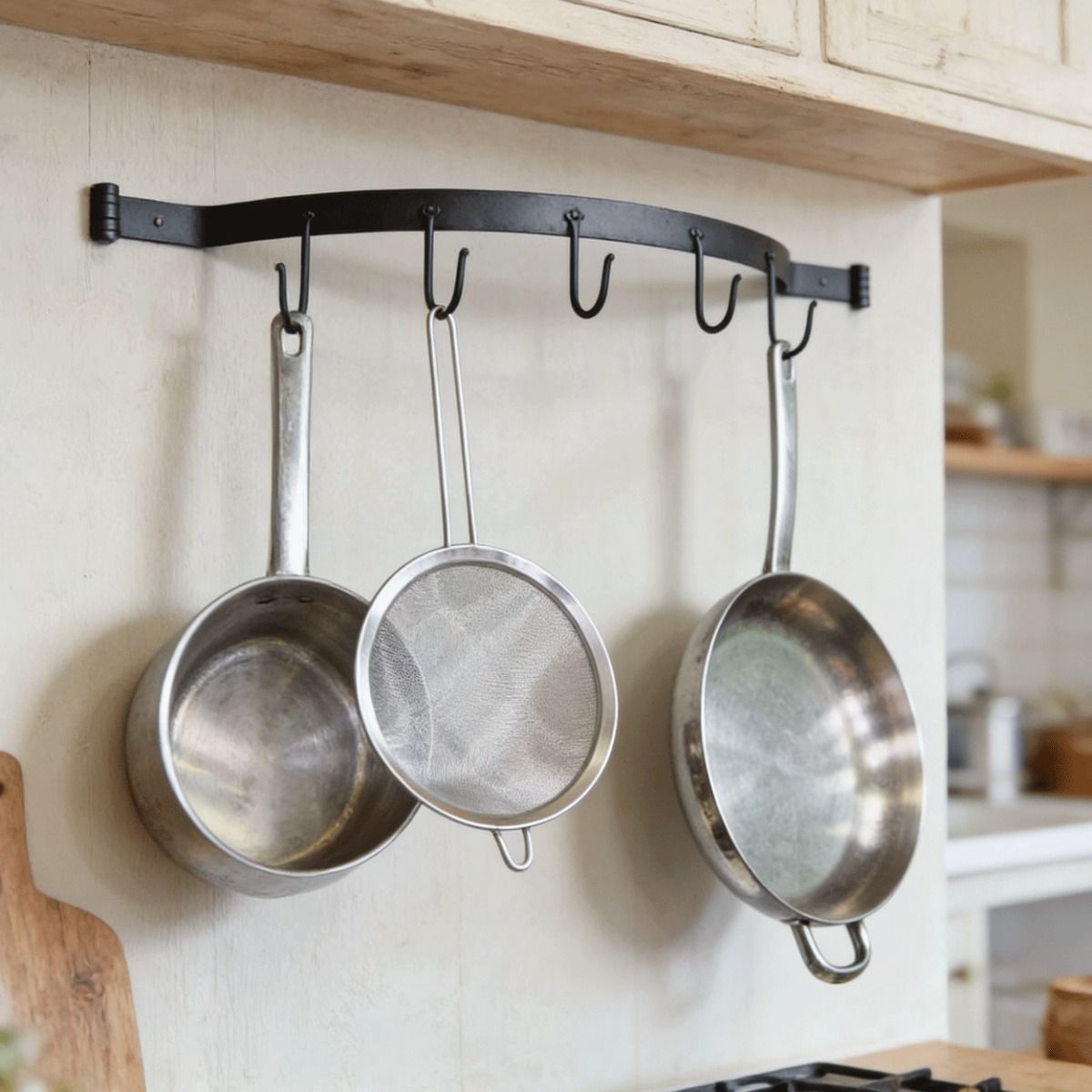 The Blacksmith Wall Mounted Bowed Kitchen Tool Rack Mounted in a Cream Coloured Kitchen with Kitchen Utensils Hanging From it - Digital Illustration