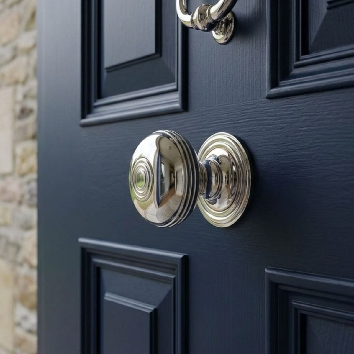 The Bright Chrome Ribbed Centre Door Knob Set on the Front of a Blue Door to a Large Home - Digital Illustration 