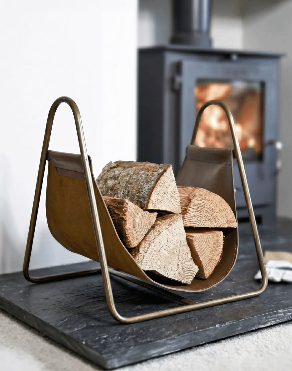 The Bronze Steel & Brown Leather Log Holder on a Black Stone Hearth next to a Modern Log Burner Stove in a Modern Home - Digital Illustration