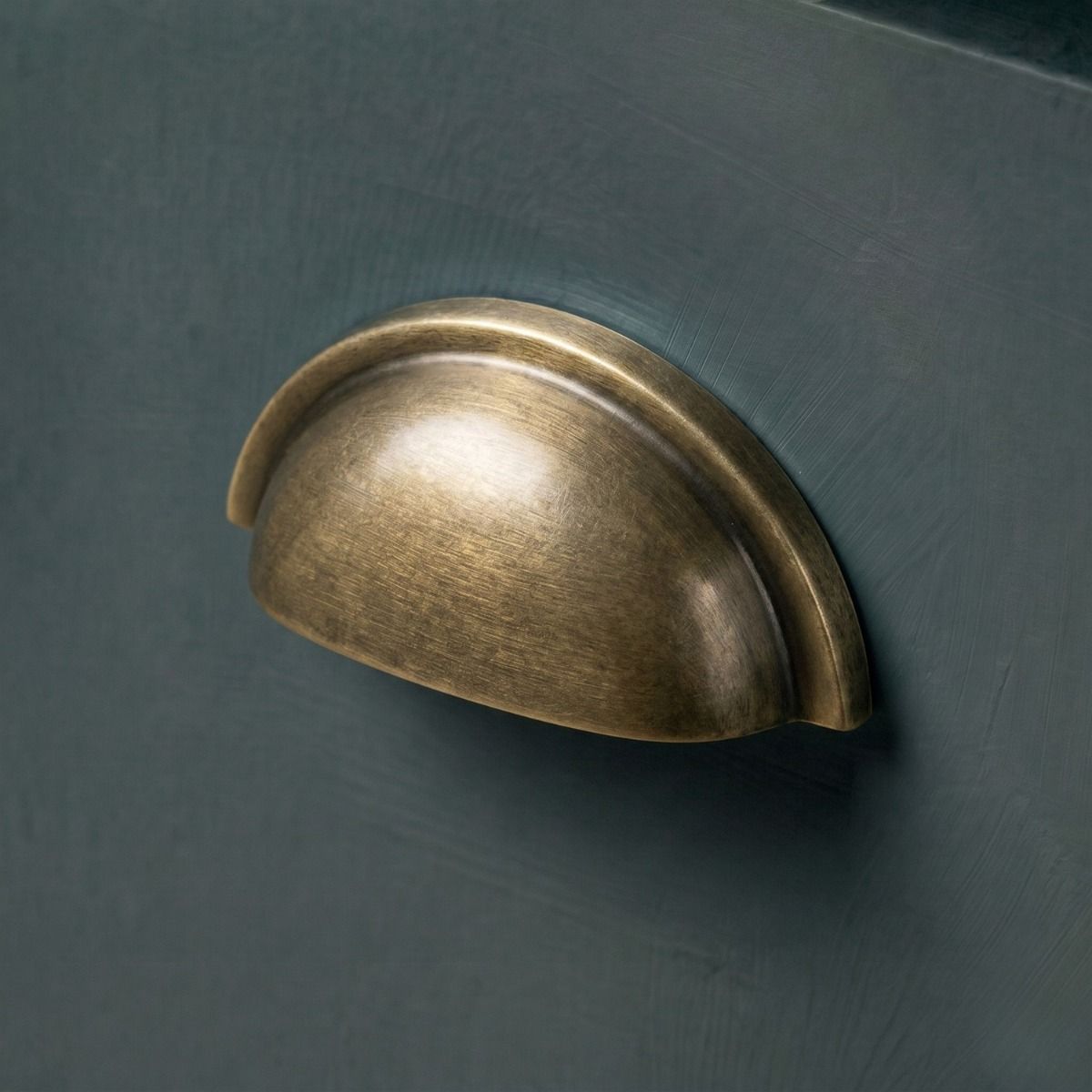 The Burnished Brass "Stratford" Traditional Cup Handle Mounted on a Wooden Blue Kitchen Cupboard Drawer - Digital Illustration