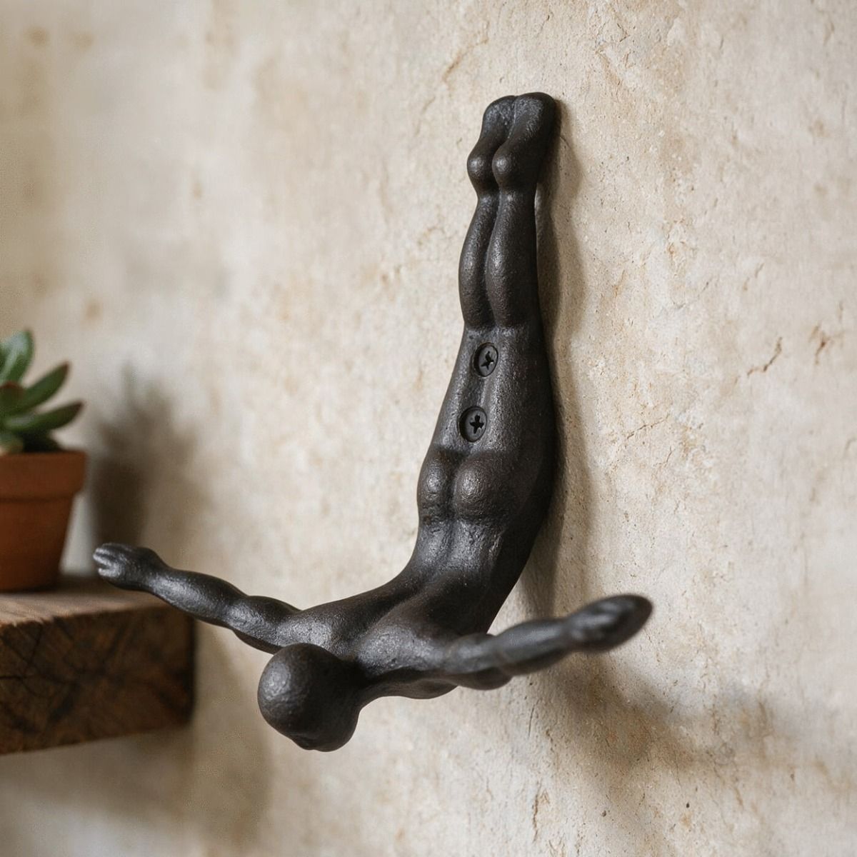 The Cast Iron "Sky Dive" Coat Hook Mounted on a Textured Cream Wall - Digital Illustration