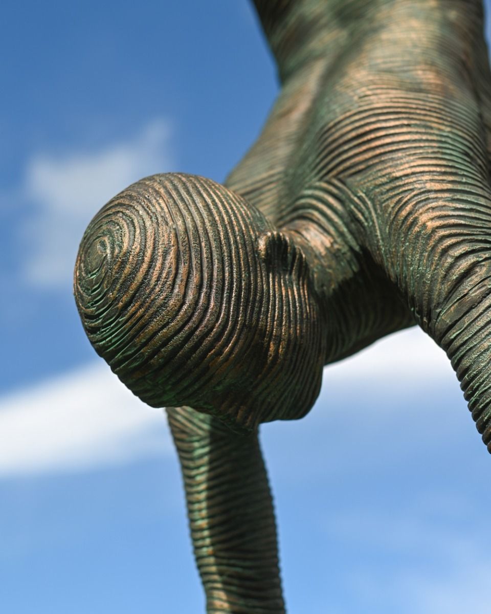 The Equilibrium Handstand Garden Sculpture in Verdigris Showing a Close up of the Head