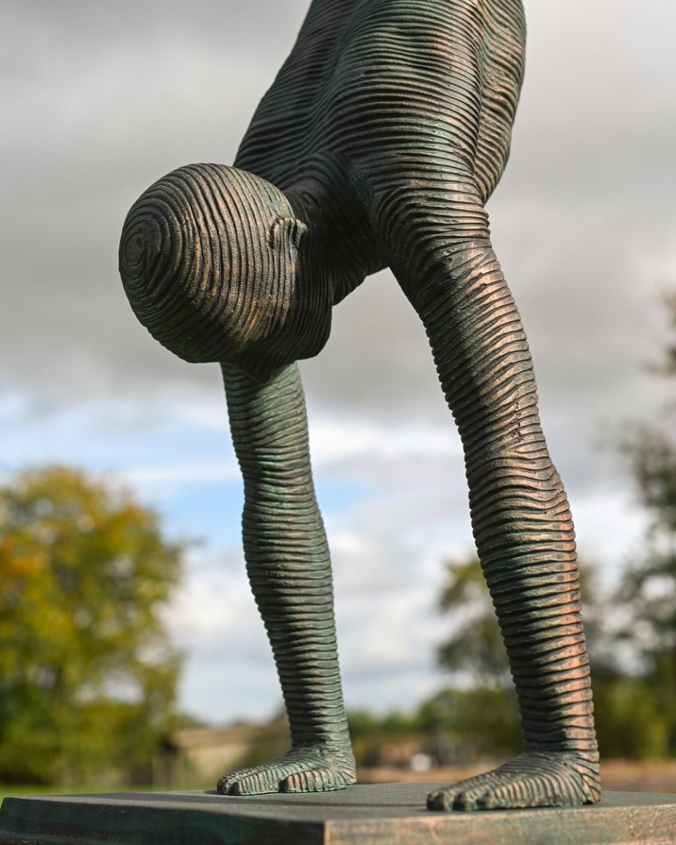 The Equilibrium Handstand Garden Sculpture in Verdigris Showing a Close up of the Head and Arms