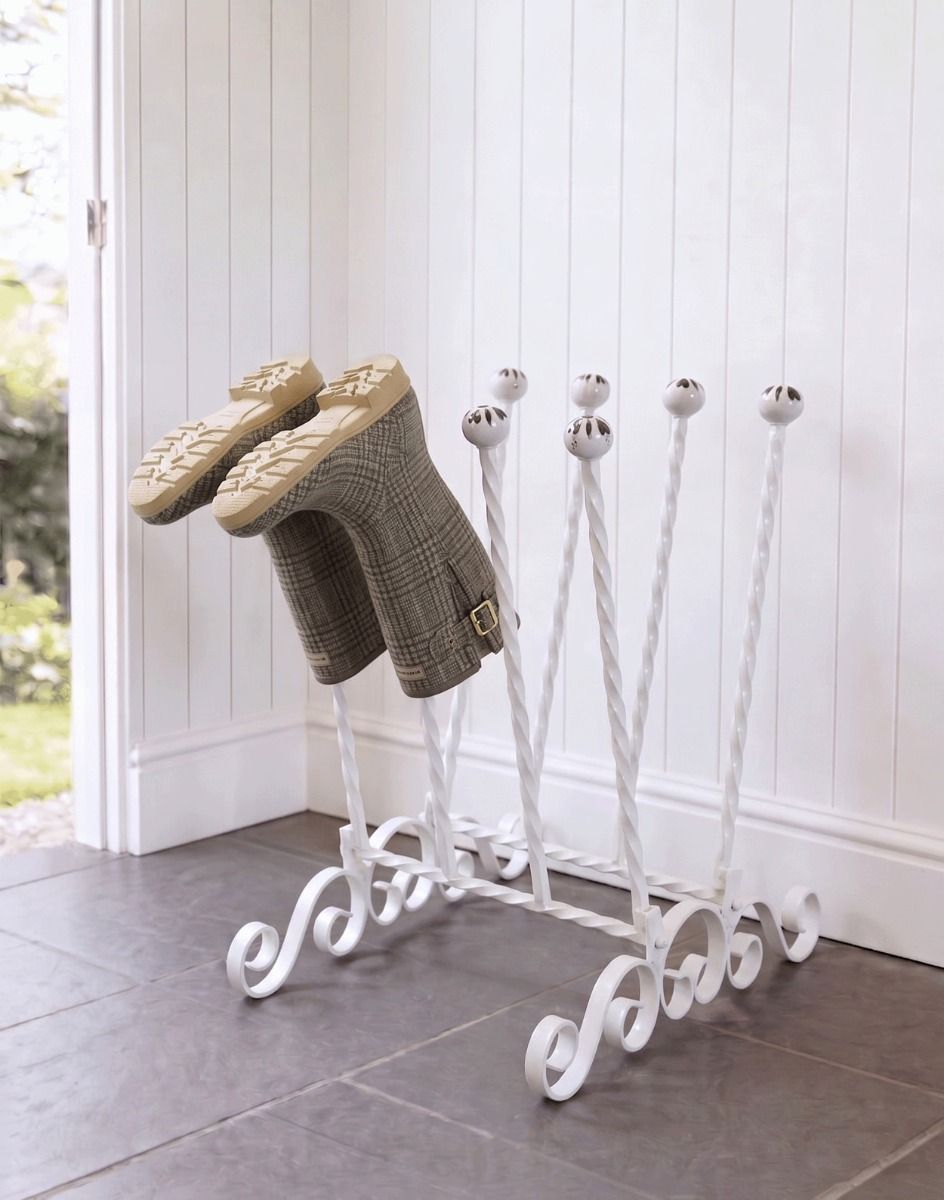 The Evesall Cream 4 Pair Ornate Boot Rack Positioned on a Stone Tile Floor in a Sunny Garden Porch - Digital Illustration 
