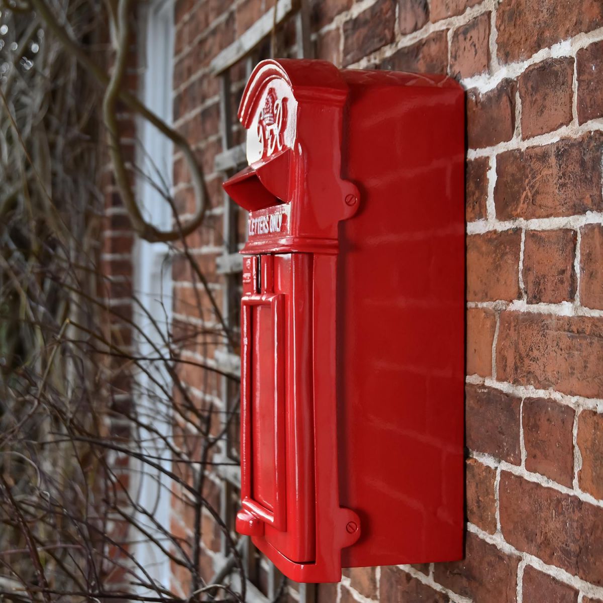 View of The King George Post Box Slim In Red Mounted on a Brick Wall