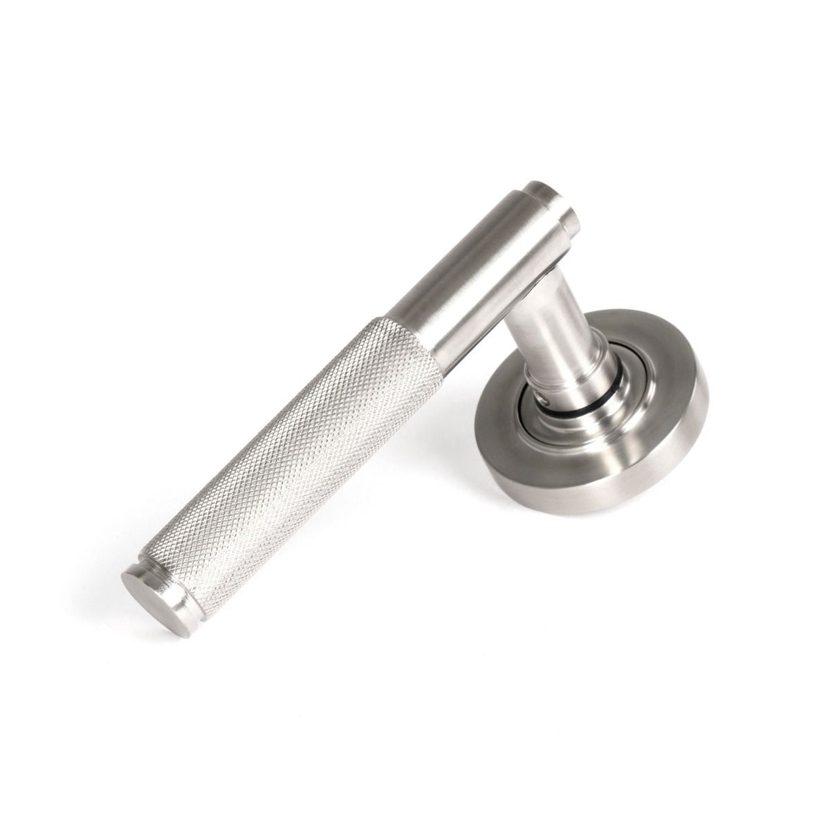 The Knurled Sprung Handle Set on a Round Rose in Satin Stainless Steel Shown at an Angle on a White Background