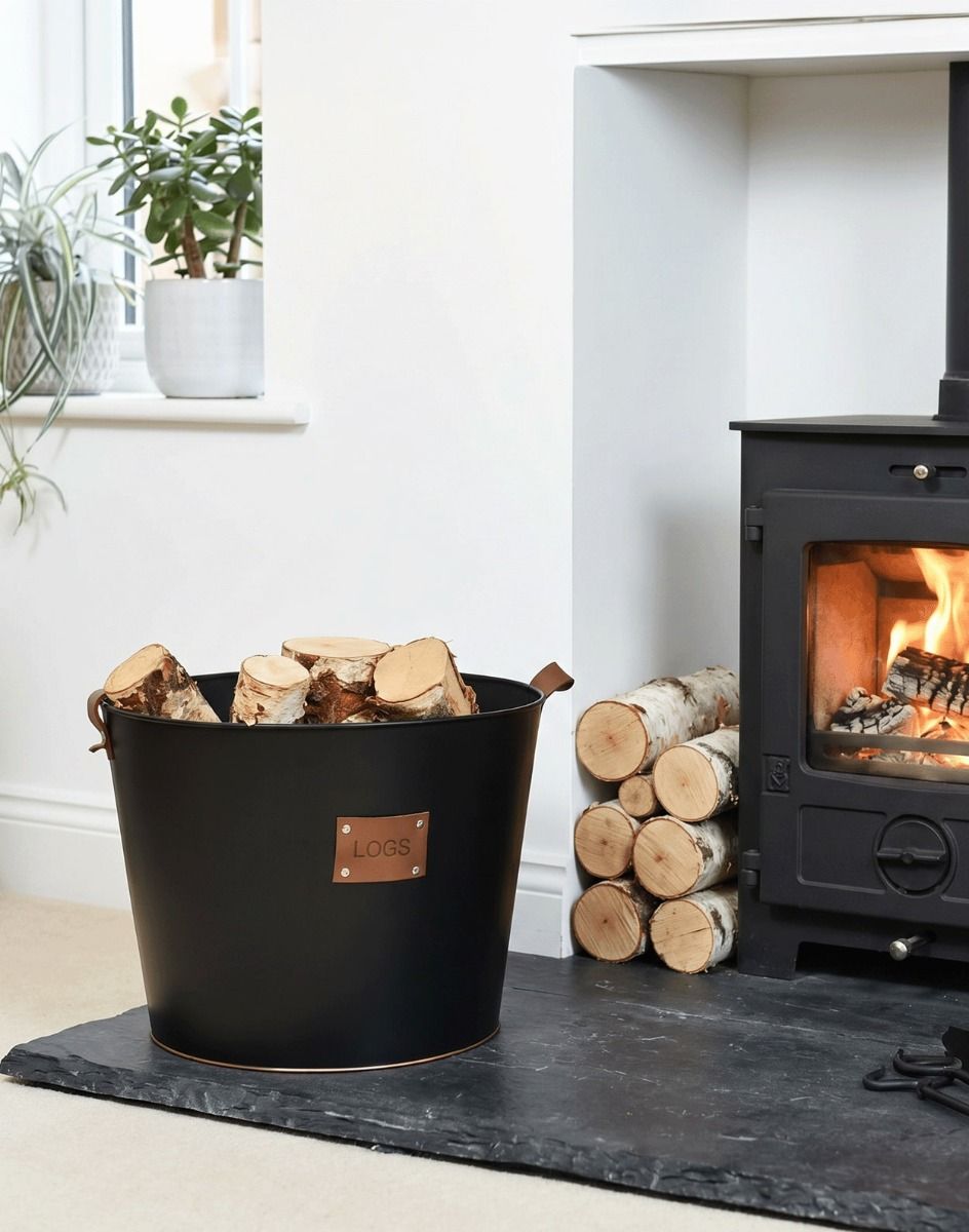 The Large "Logs" Black Log Basket Seen Placed on a Stone Hearth in a Modern Home next to a Log Burner - Digital Illustration
