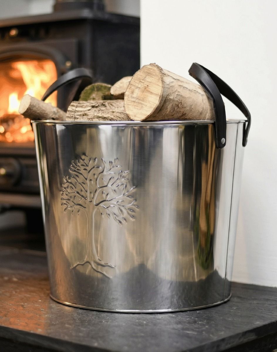 The Large Polished Steel "Tree of Life" Log Bucket next to a Lit Log Burner in a Modern Home Setting - Digital Illustration
