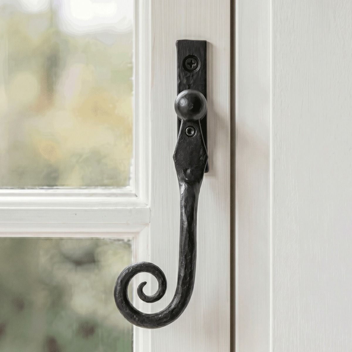 The Left Handed 16mm Beeswax Monkeytail Espagnolette Window Handle Fitted on a Traditional Window Frame in a Country Home - Digital Illustration 
