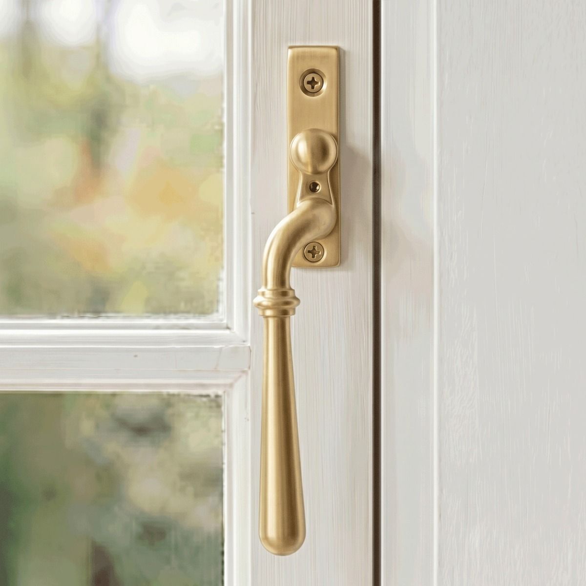 The Left Handed 16mm Modern Satin Brass Espagnolette Window Handle Mounted on a Classic White Coloured Window Frame in a Country Home - Digital Illustration