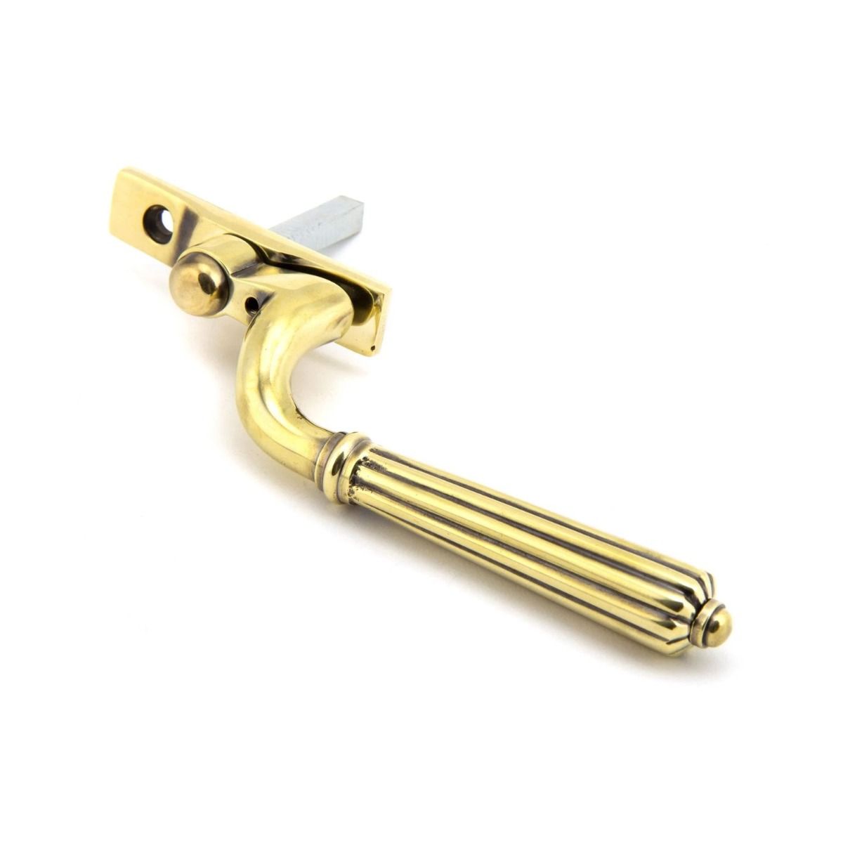 The Left Handed Aged Brass Reeded Georgian Espagnolette Window Handle on a White Background Shown on a White Background Shown on its Side
