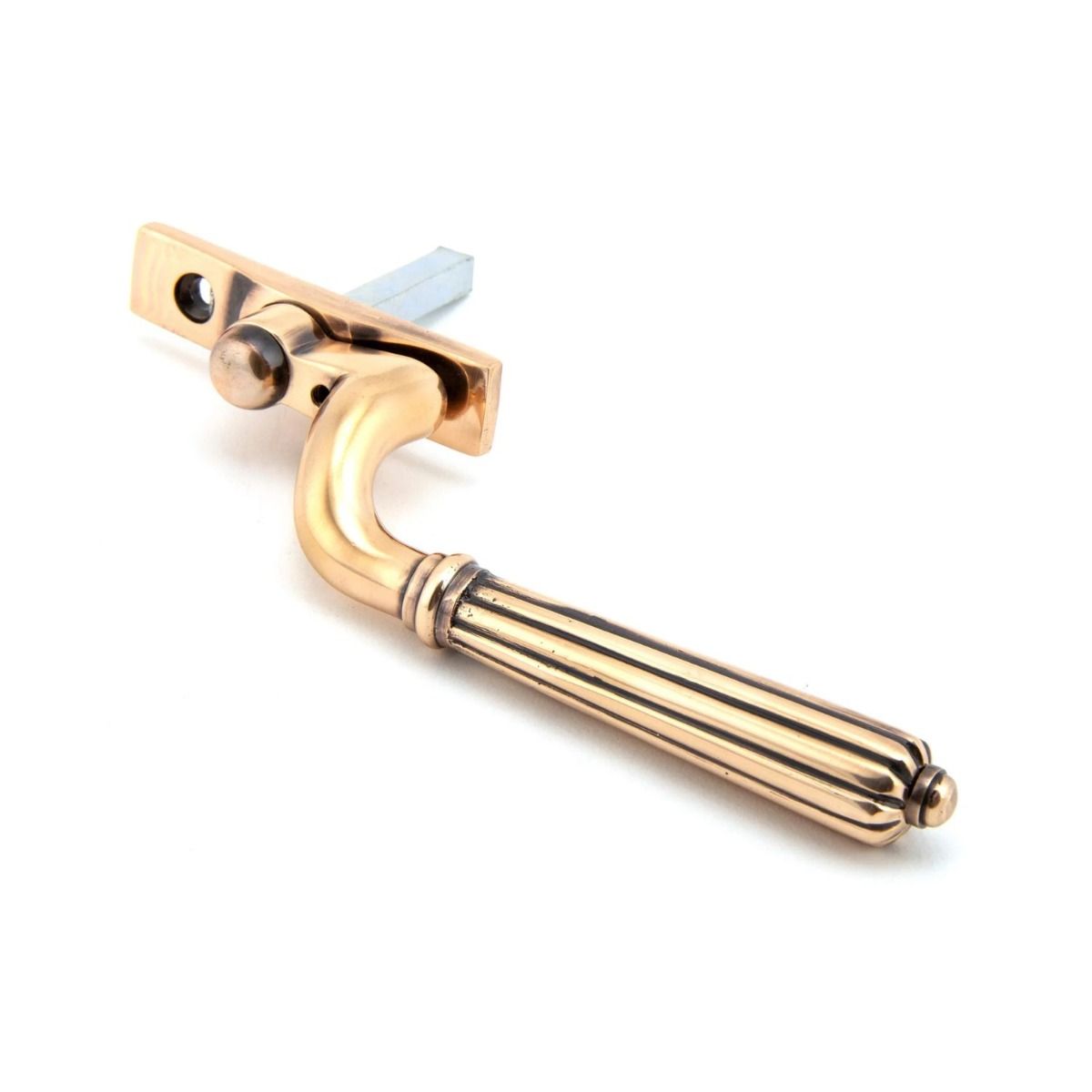 The Left Handed Polished Bronze Reeded Georgian Espagnolette Window Handle on a White Background Shown on its Side 
