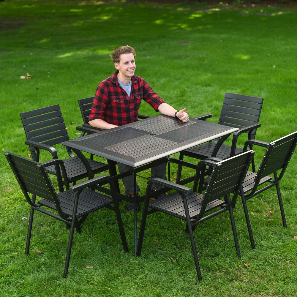 The Linea 6-Seater Outdoor Garden Dining Set in Black With a Man Sat Relaxing at the Table