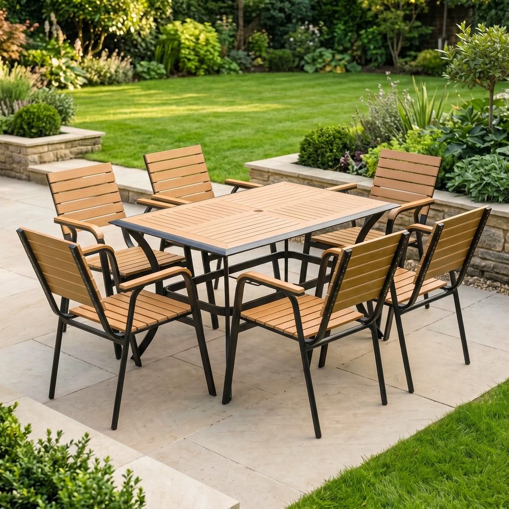 The Linea 6-Seater Outdoor Garden Dining Set in Teak in a Sunny Low Walled Garden Surrounded by Plants
