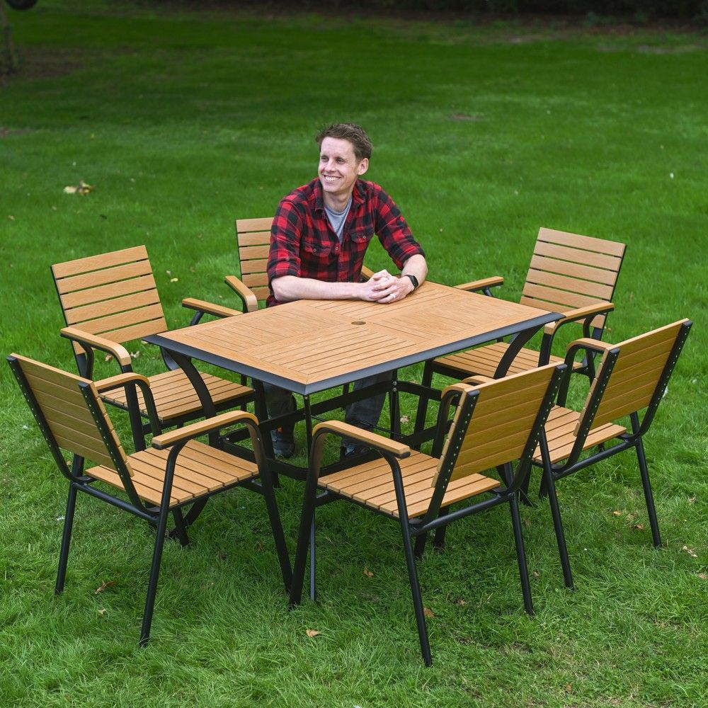 The Linea 6-Seater Outdoor Garden Dining Set in Teak With a Man Sat Relaxing at the Table