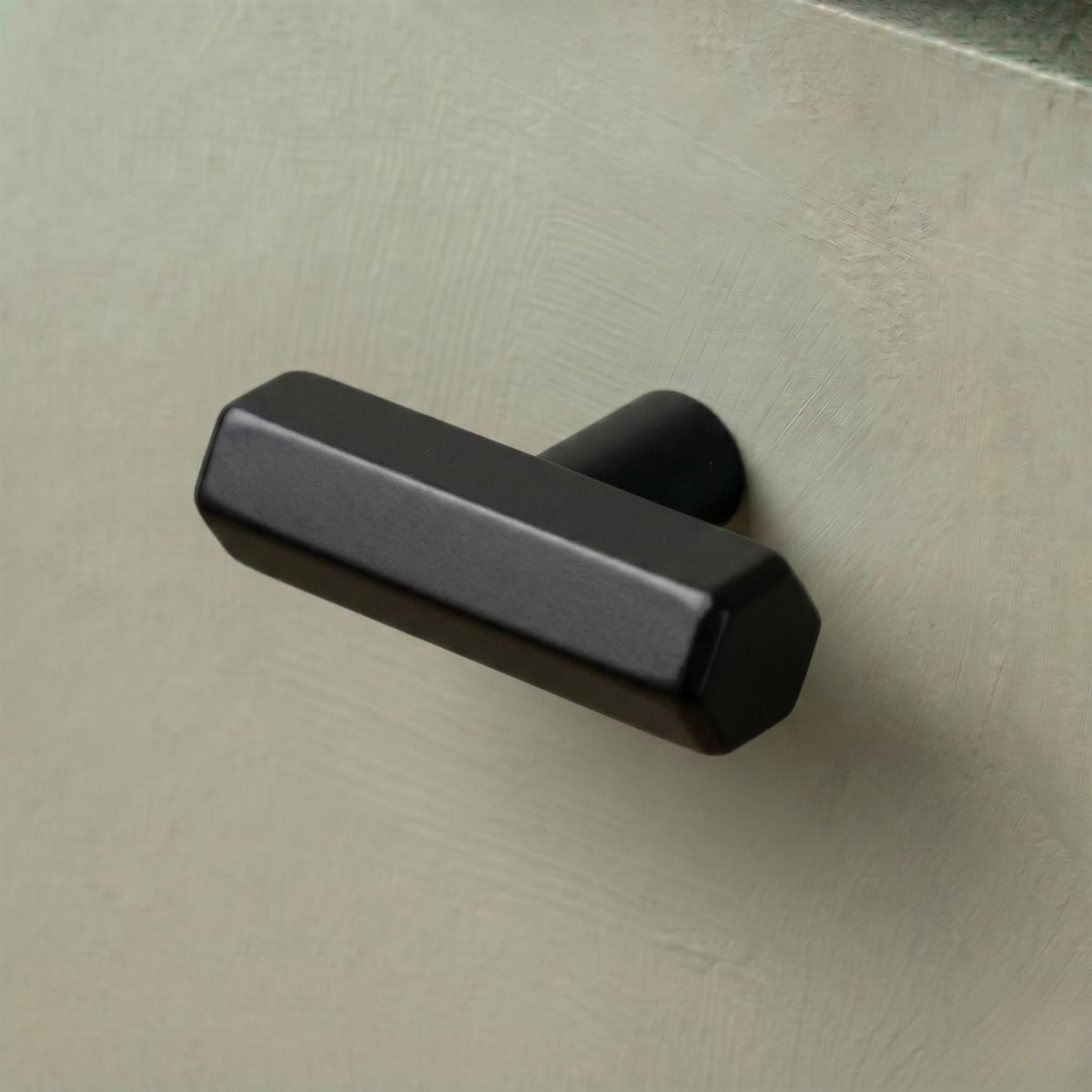 The Matt Black "Lexington" Hex T-Bar Cabinet Handle Mounted on a Green Kitchen Cupboard Drawer - Digital Illustration 