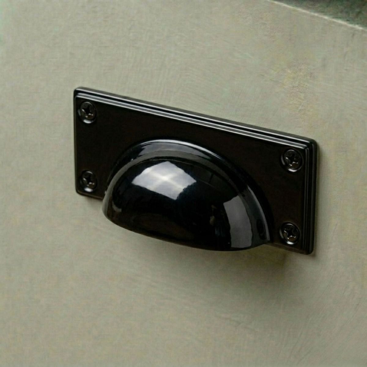 The Midnight Black Rectangular Drawer Pull with Curved Handle Fitted on a Green Kitchen Cupboard Drawer - Digital Illustration 