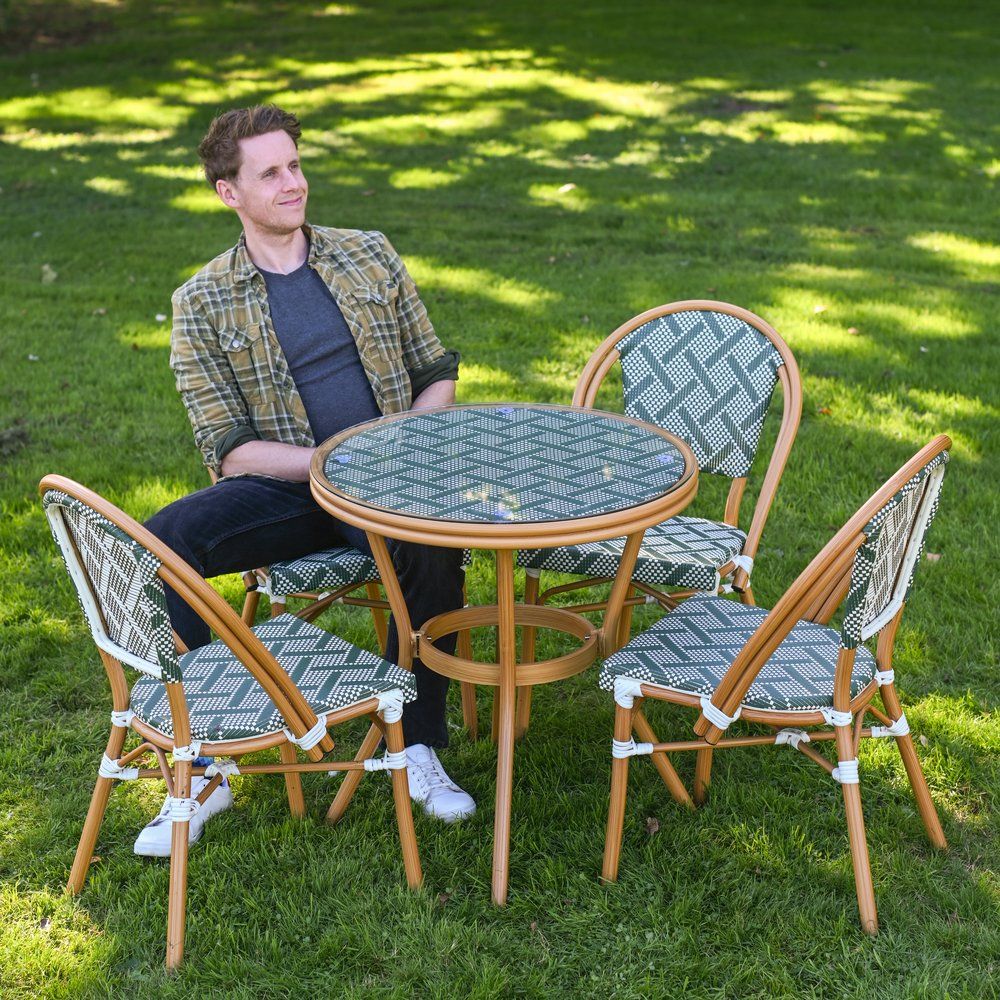The Orbis Diamond 4-Seater Bistro Dining Set in Green & White With a Man Sat down on a Chair on a Garden lawn