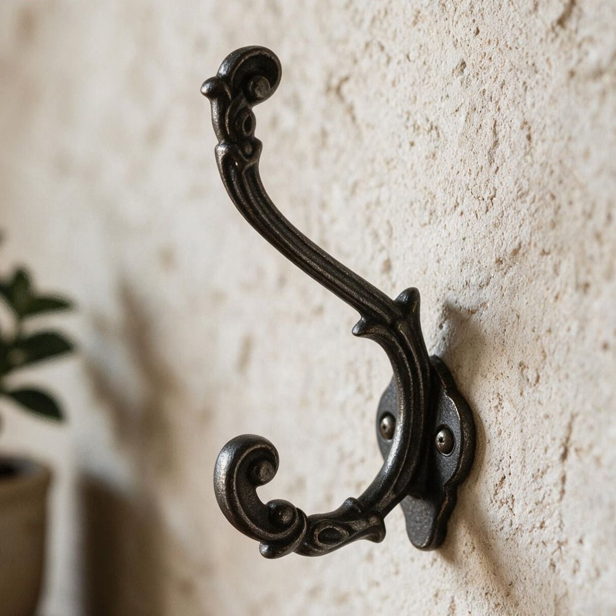 The Ornate Scroll coat hook in Natural Iron Fitted onto a Textured Magnolia Coloured Wall - Digital Illustration