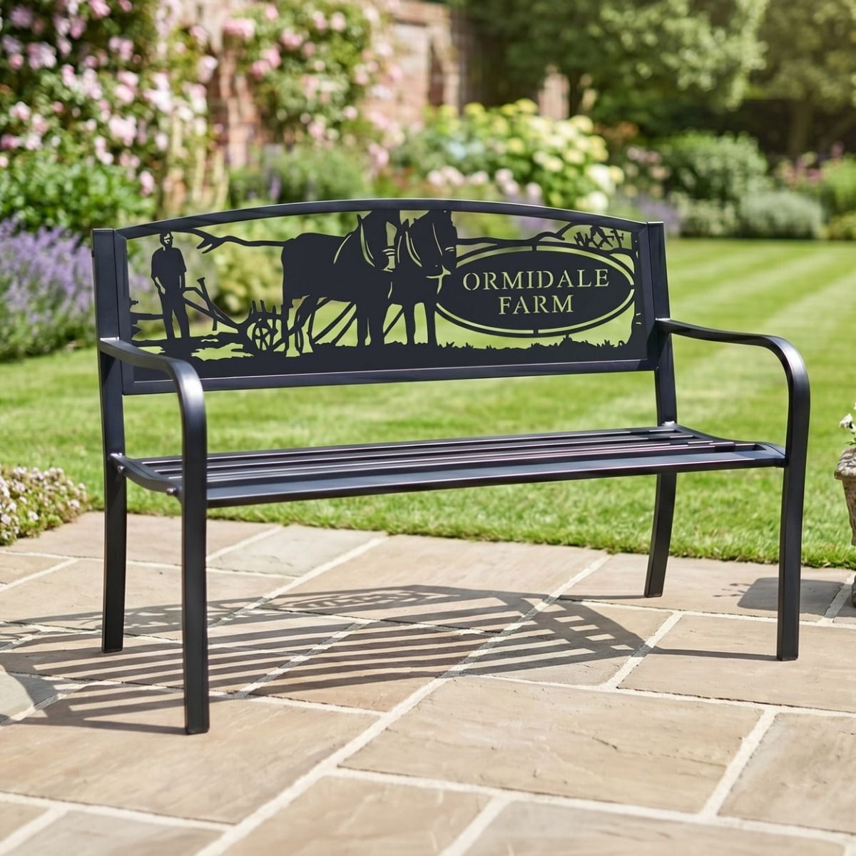 The Personalised Horse & Plough Iron & Steel Park Bench in Black in a Sunny Garden with a House Name on the Back Rest - Digital Illustration