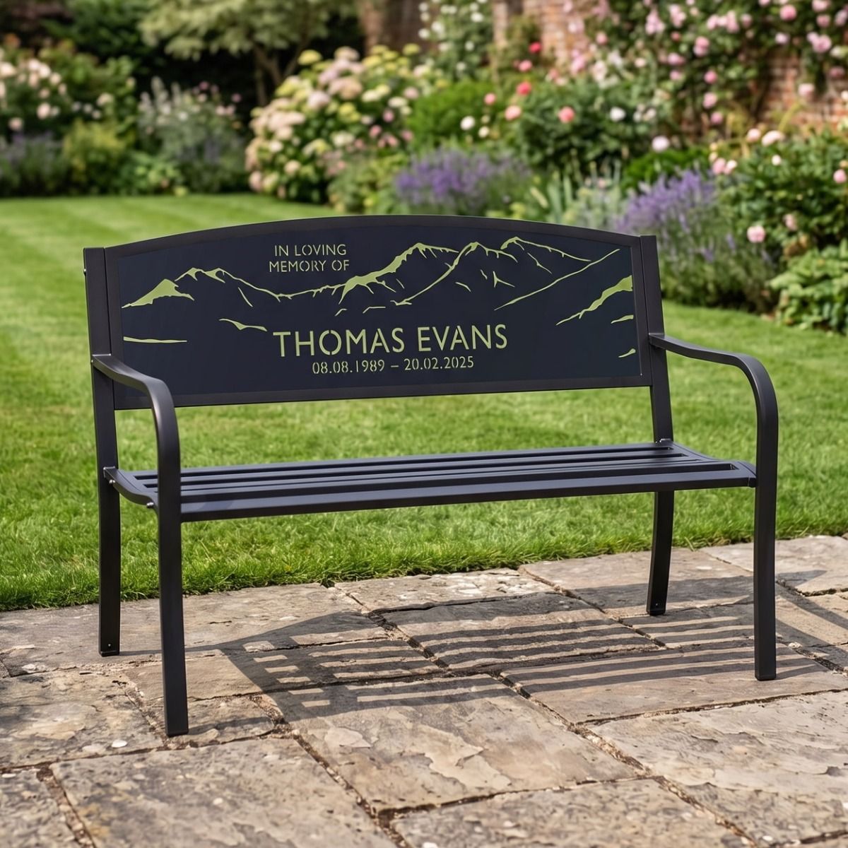 The Personalised Mountain Landscape Memorial Bench next to a Garden Lawn with Custom Name and Dates to Commemorate a Loved One