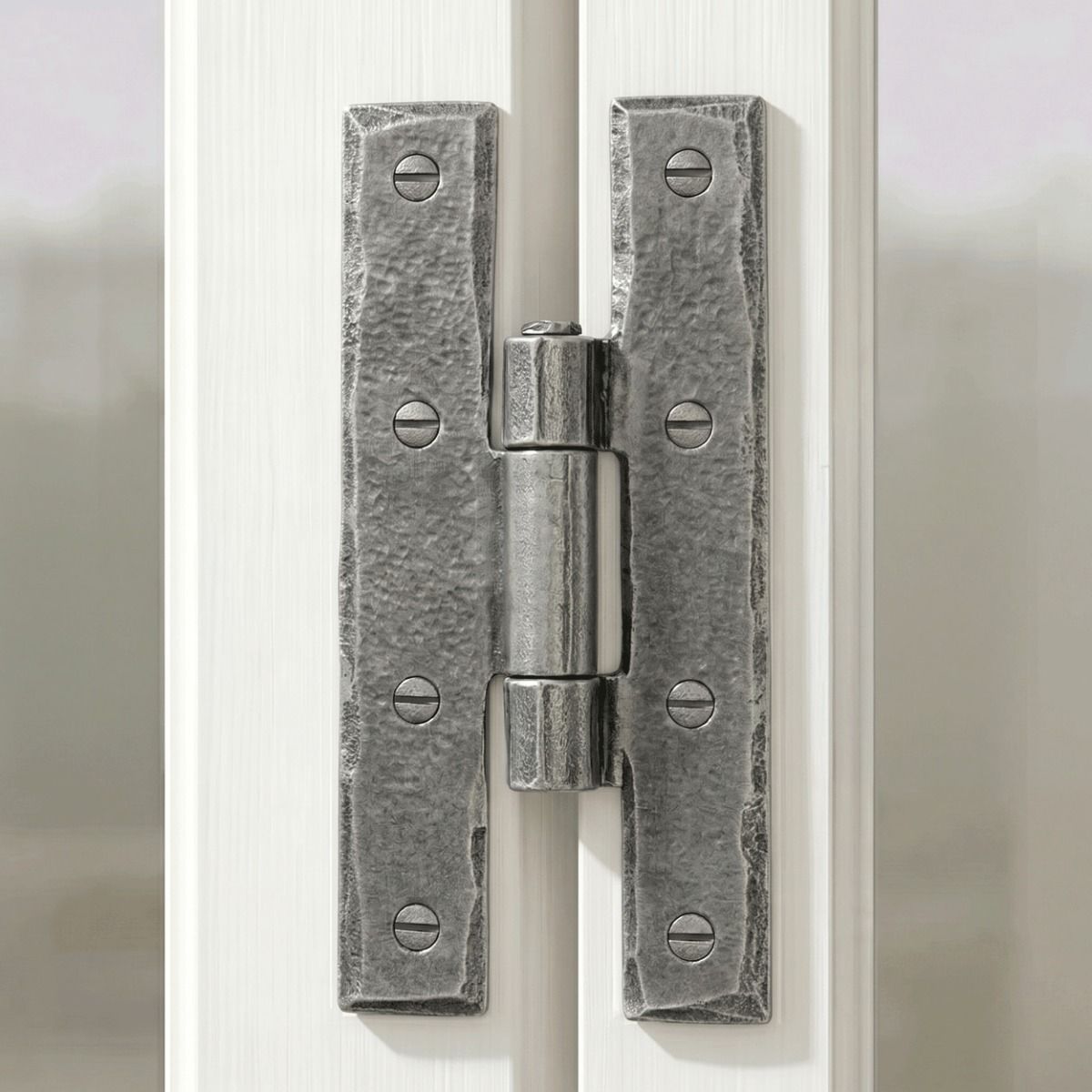The Pewter 3¼" Inch H Hinge Pair Shown Attached to a Vintage White Window Frame in a Country Home - Digital Illustration 