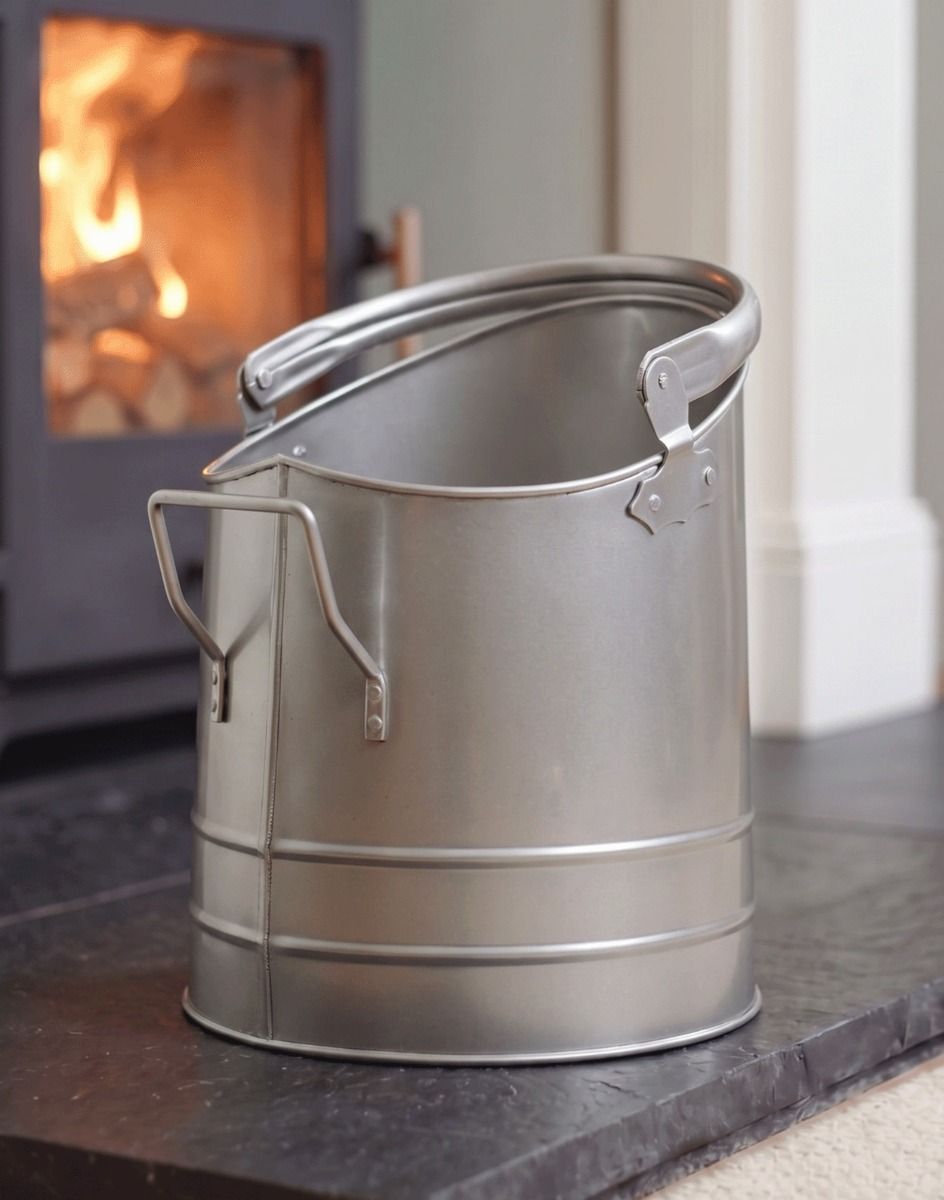 The Pewter Finish Traditional Fireside Log and Coal Bucket In Front of a Lit Fireplace in a Contemporary Home - Digital Illustration