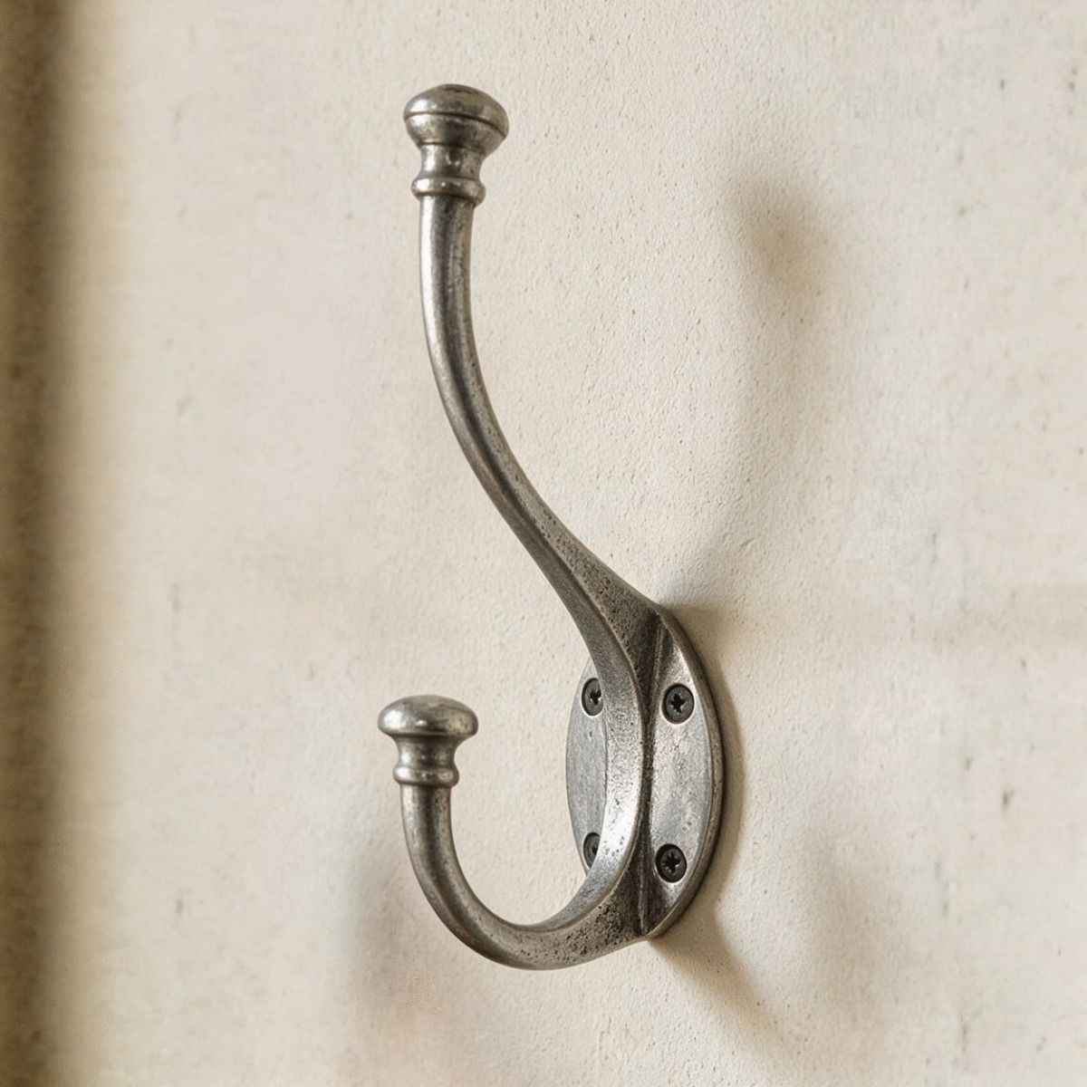 The Pewter Wall Mounted Coat Hook Shown Close up on a Cream Wall - Digital Illustration 