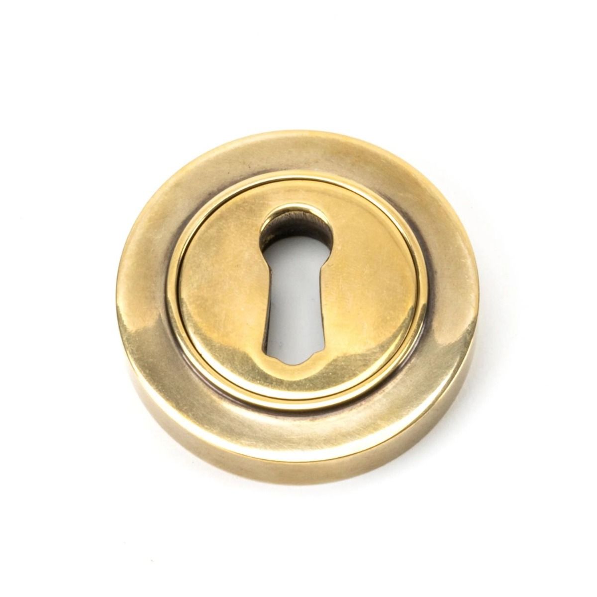 The Plain Concealed Standard Keyhole Escutcheon - Aged Brass on a White Background