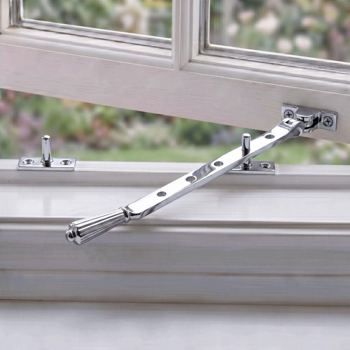 The Polished Chrome Georgian Reeded Casement Window Stay Fitted on a White Window Frame in a Country Home - Digital Illustration