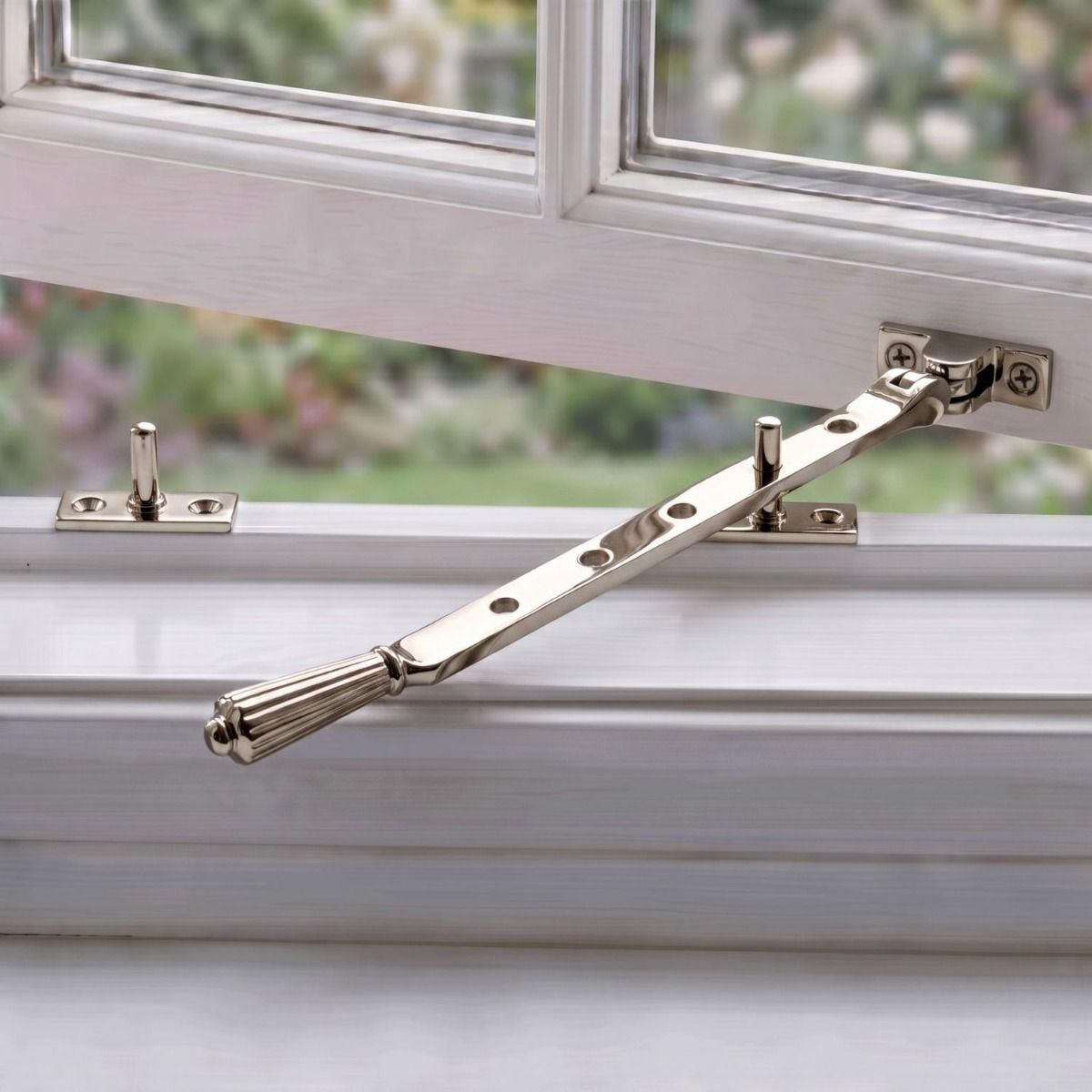 The Polished Nickel Georgian Reeded Casement Window Stay on a Traditional White Wooden Window Frame - Digital Illustration