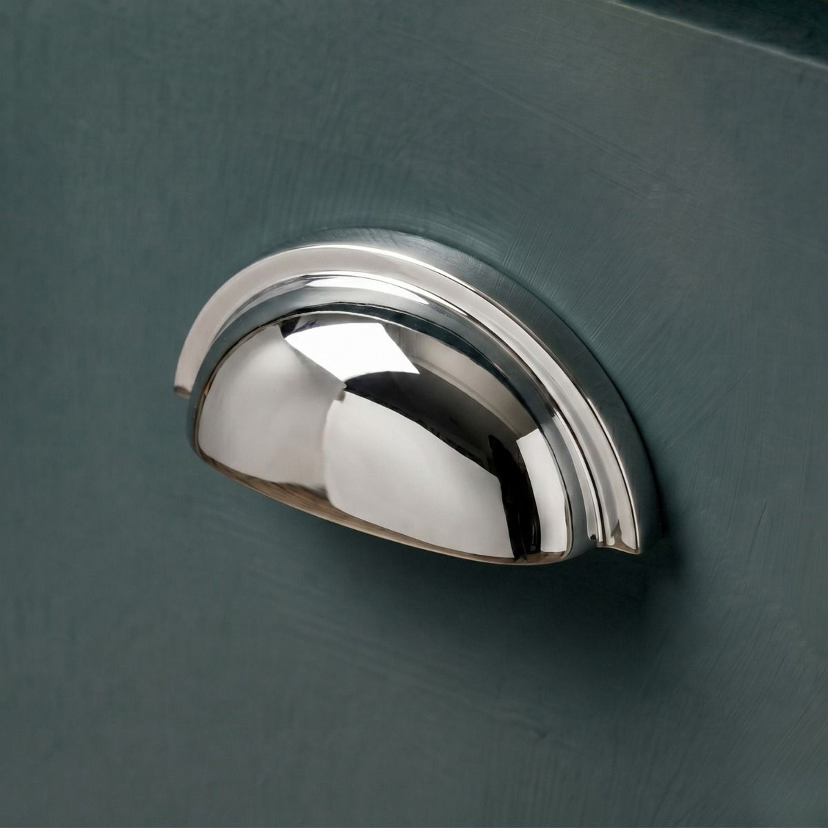 The Polished Nickel Version of the "Stratford" Traditional Cup Handle Mounted on a Wooden Blue Kitchen Cupboard Drawer - Digital Illustration 