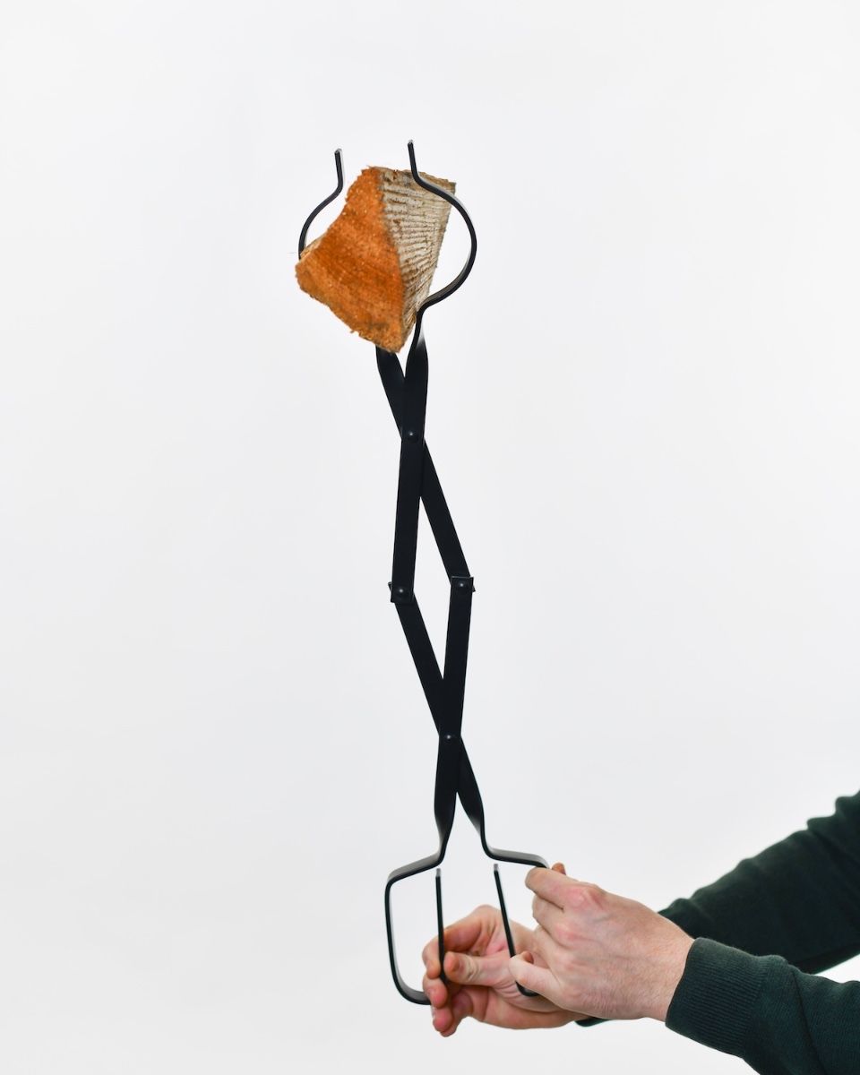 The “Prism” Steel Fire Place Tongs holding log upright