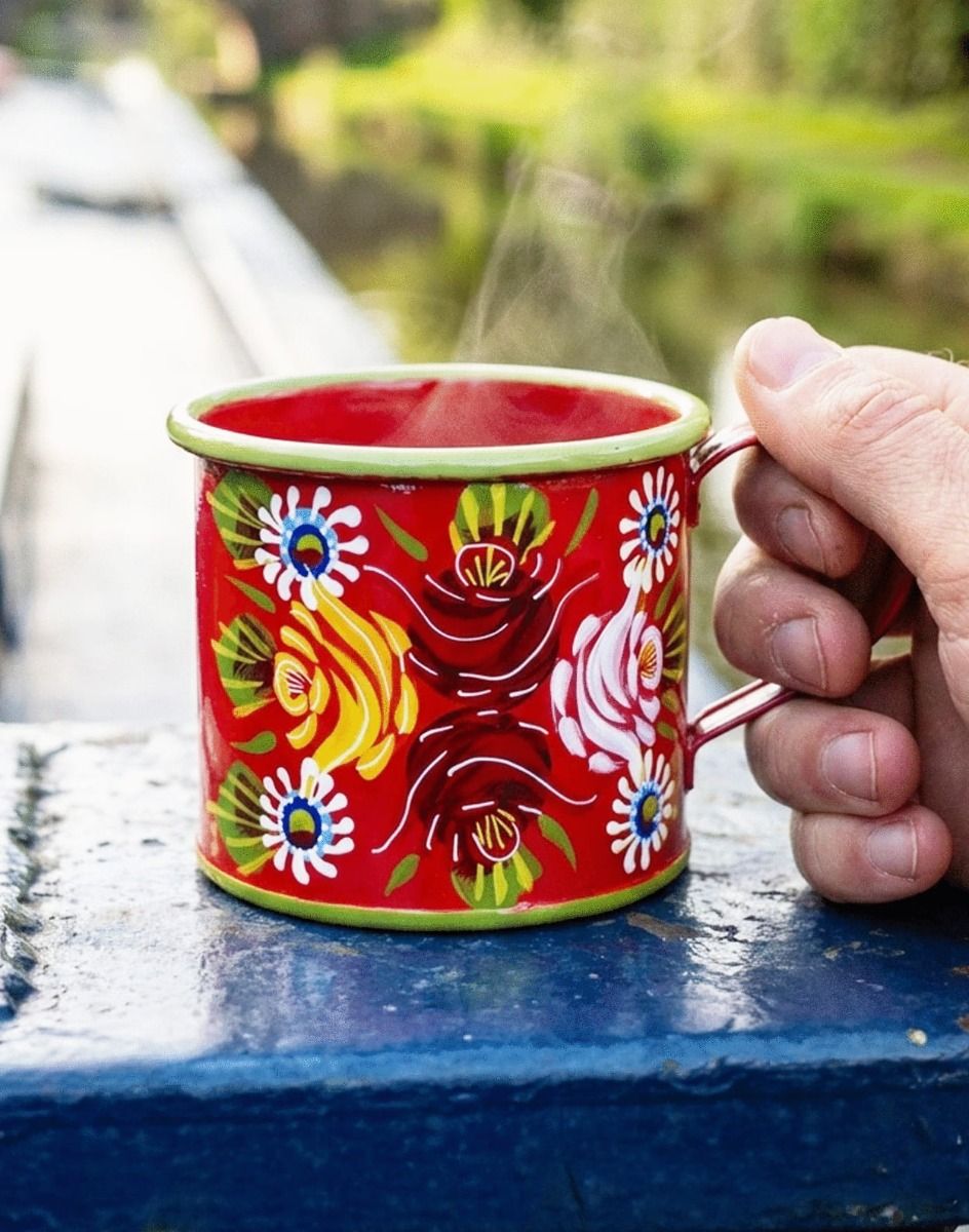 The Red Buckby Narrowboat Style Hand Painted Mug Being Held on a Blue Canal Boat Outside - Digital Illustration 