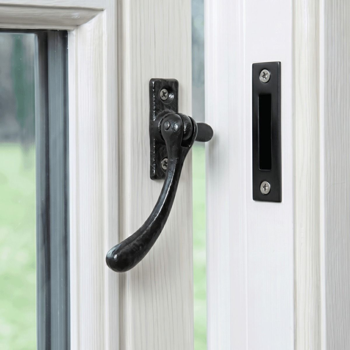 The Reversible Simplistic Black Iron Casement Fastener Displayed on a Classic White Painted Window Frame in an Open Position - Digital Illustration